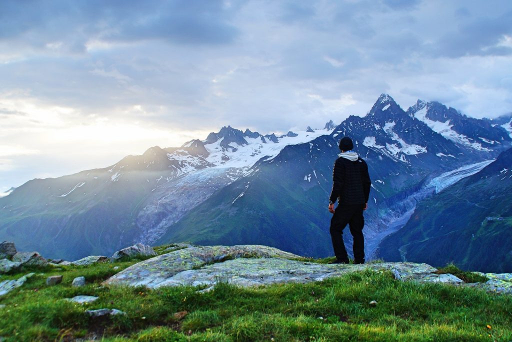 Wanderer mit Blick auf die schneebedeckten berge bei Sonnenaufgang