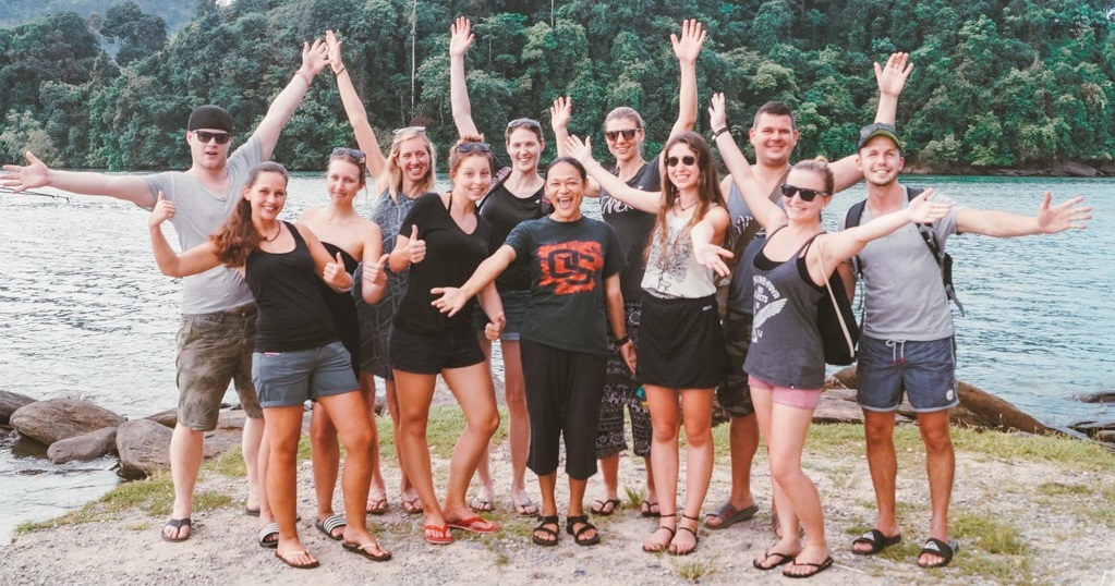 Gruppe von Menschen auf einer Insel streckt die Arme aus