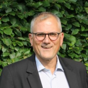 Dirk Schmülgen ©Futour Porträt von Dirk Schmülgen vor einem Hintergrund mit Pflanzen.