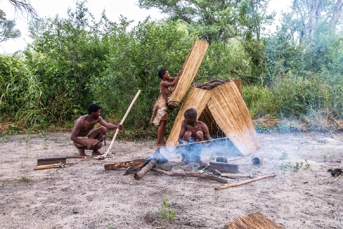Personen der Khwe Gemeinde beim Feuer machen