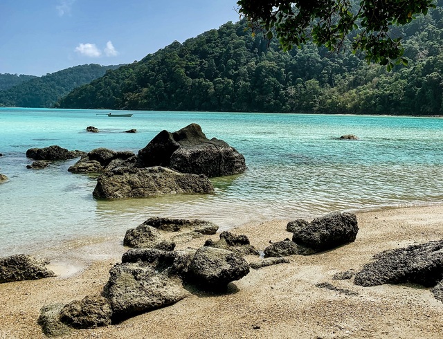 Strand mit türkisblauem Wasser und Steinen