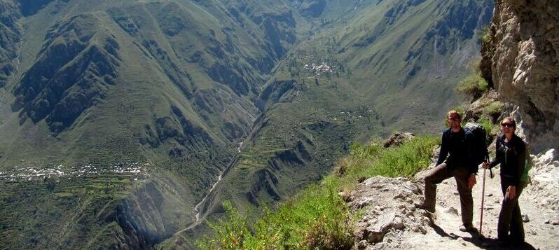 zwei Personen auf einem Wanderweg mit Bergen im Hintergrund