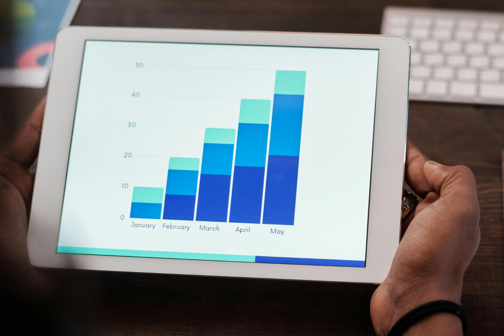 Header KPI Blog ©pexels Mikael Blomkvist Two hands holding a tablet displaying various statistics.